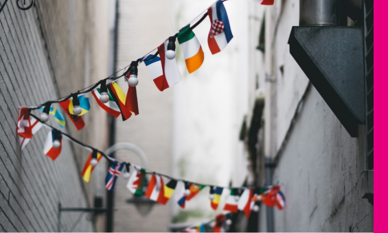 multiple country flags hanging on street