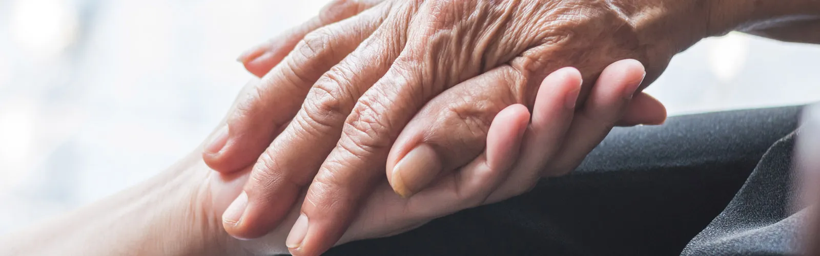 young hand holding elderly hand